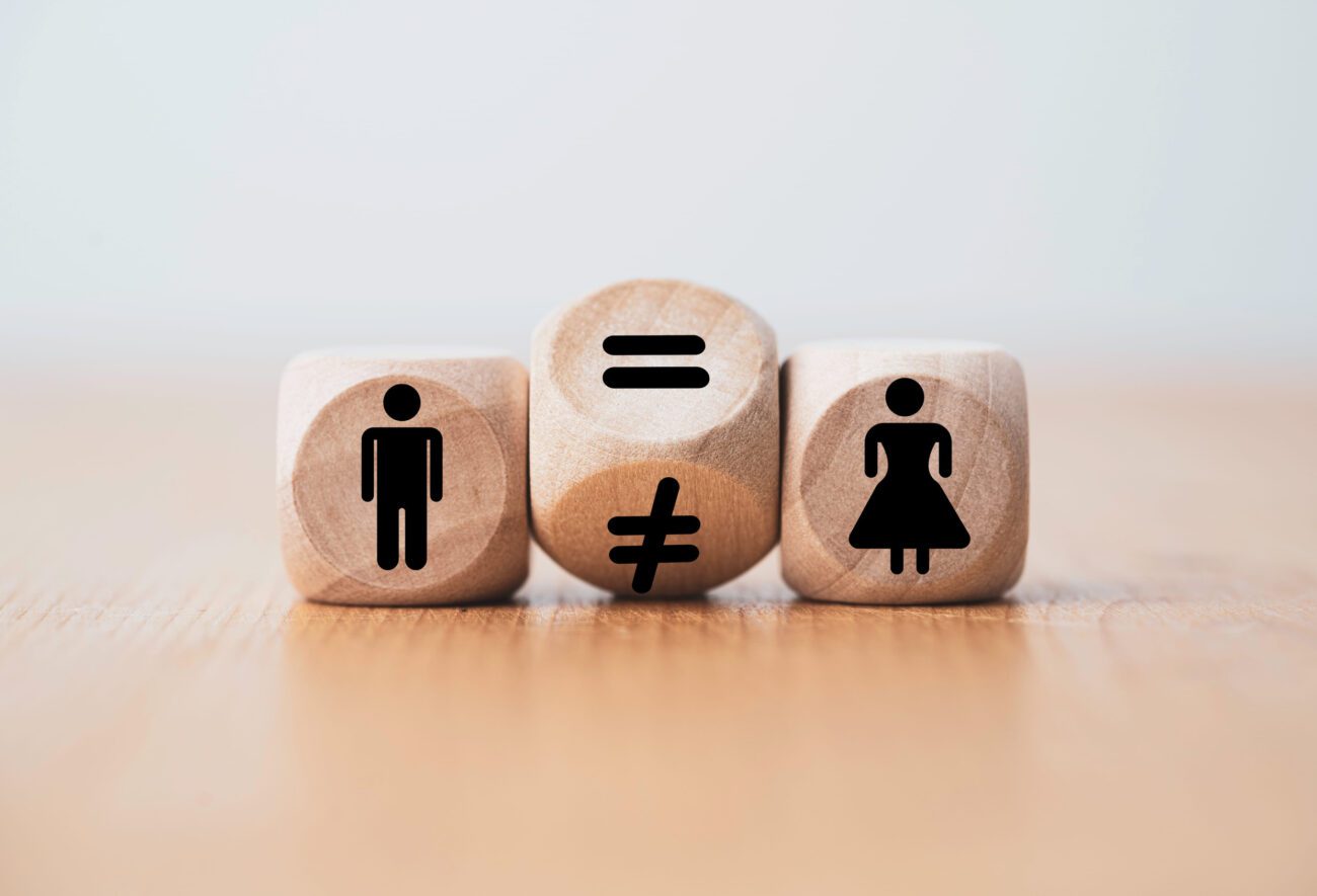 773374 Cantalapiedra Abogados - Sonajero.es Wooden blocks show a man icon, an equals/not-equals pair in the center, and a woman icon—conveying gender equality and inequality.